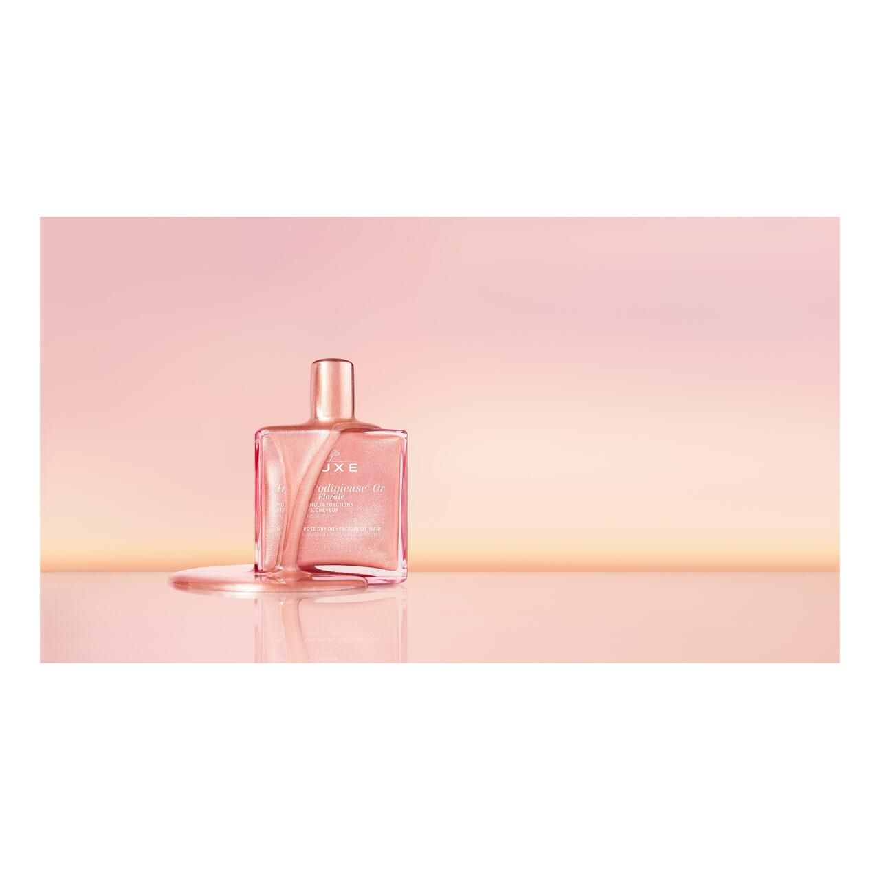 Nuxe Huile Prodigieuse® Or Florale. Rosa Flasche mit goldfarbenem Verschluss. Produkt auf weißem Hintergrund.