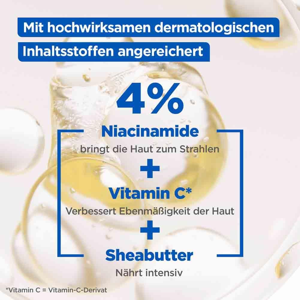 Nahaufnahme von Flüssigkeitstropfen. Text: 4% Niacinamide, Vitamin C, Sheabutter.