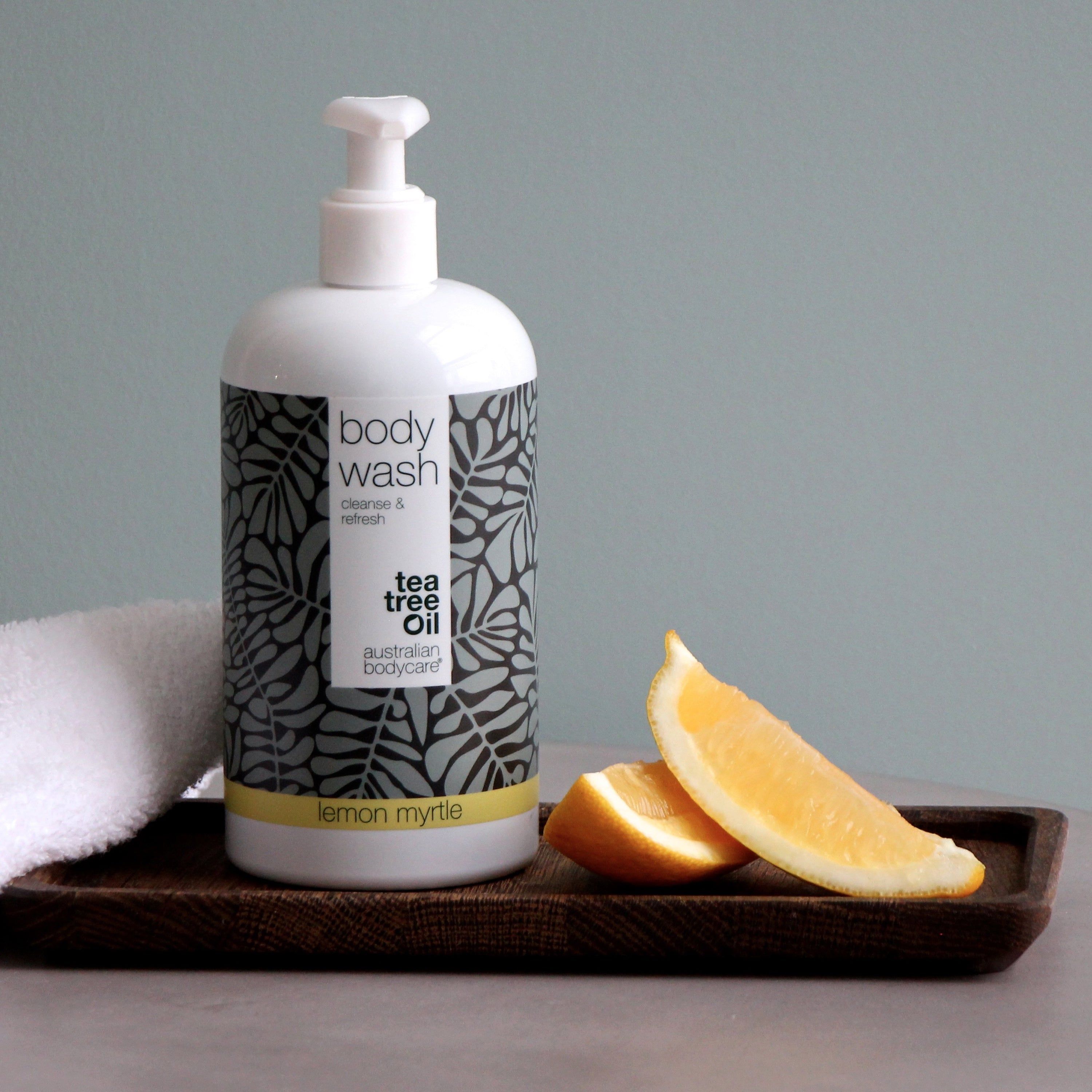 Flacon blanc avec « body wash » et « australian bodycare ». Sur plateau avec tranches de citron.