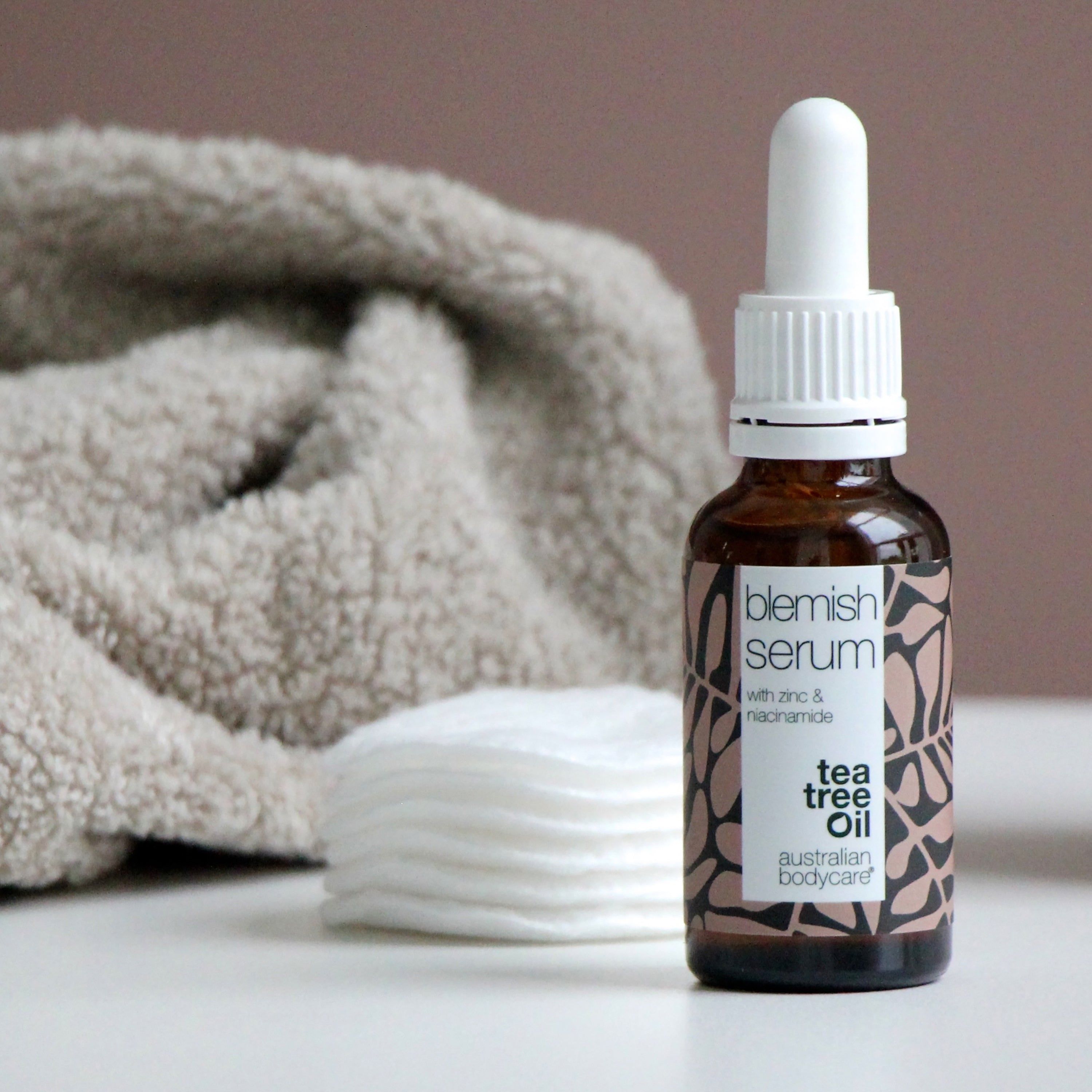 Flacon de Blemish Serum, cotons et serviette. Inscription : Blemish Serum, Tea Tree Oil. Marque : Australian Bodycare.