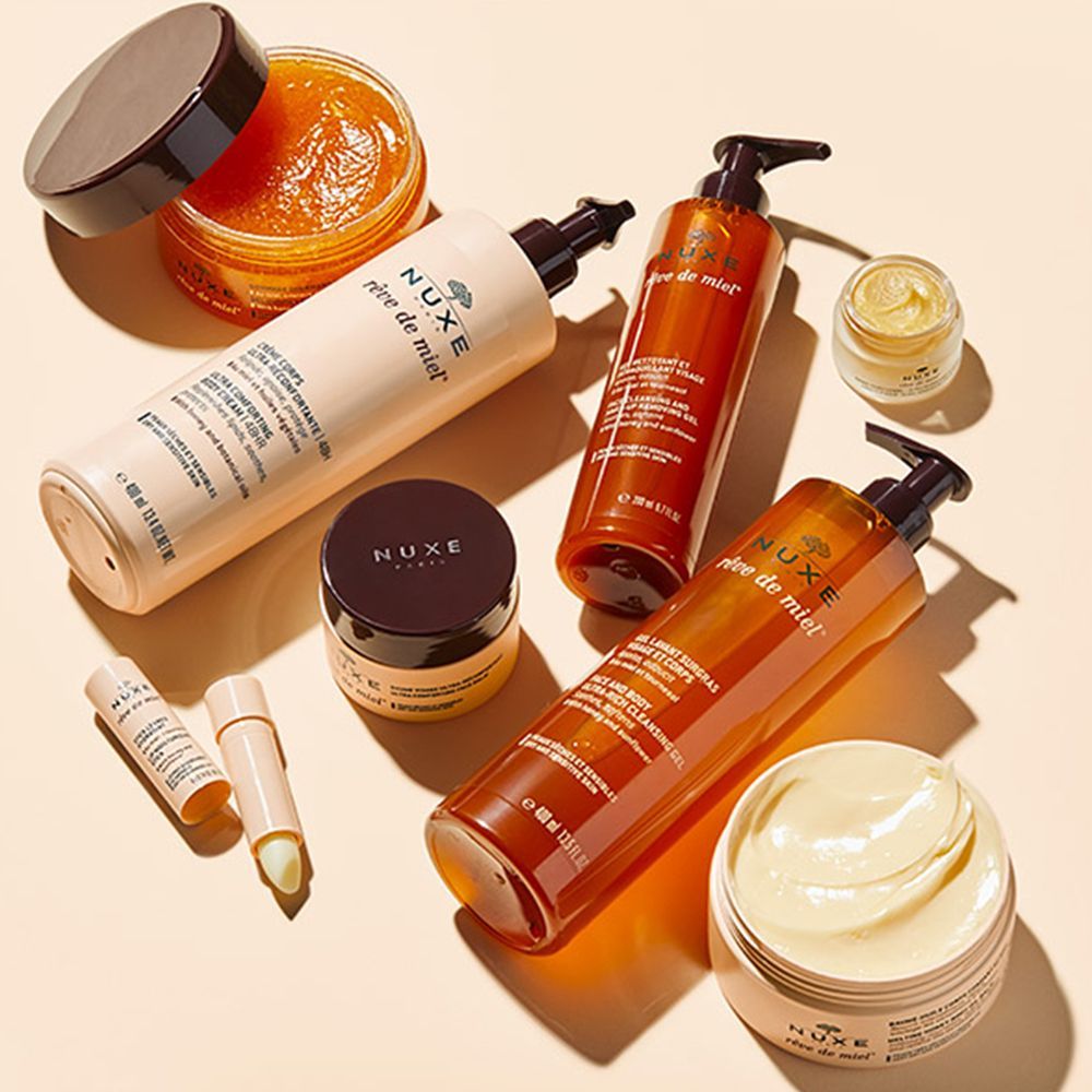 Divers produits NUXE Rêve de Miel. Flacons, pots et baume à lèvres. Emballages beiges et bruns.