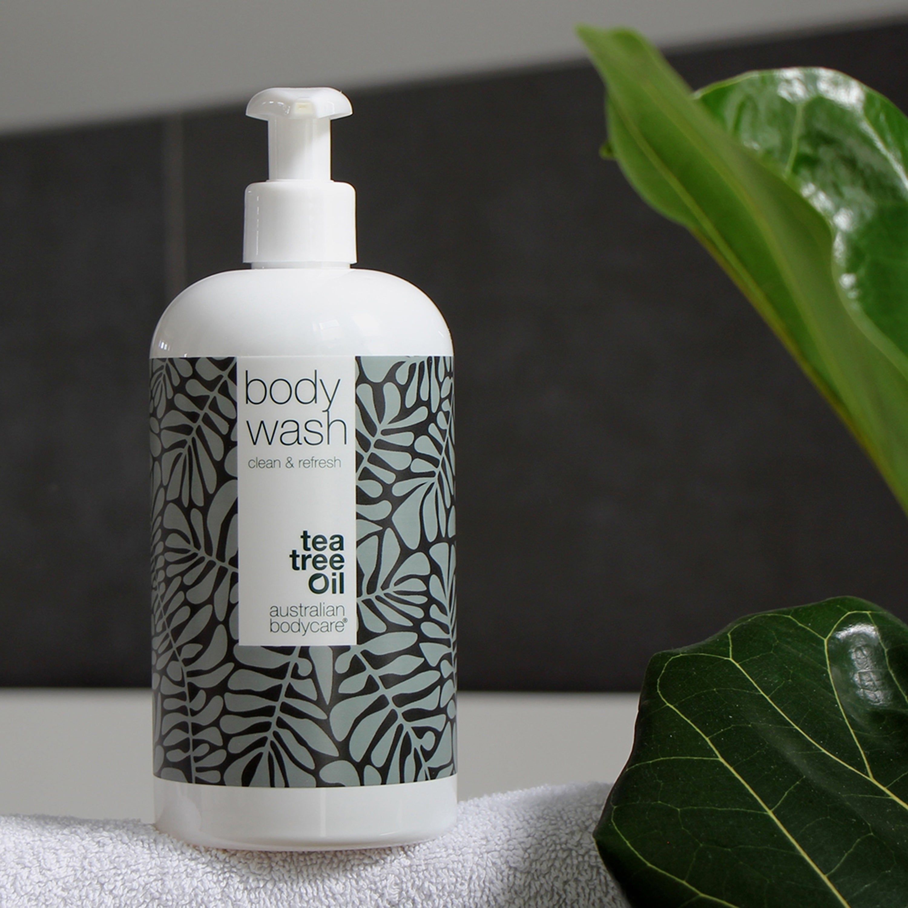 Flacon blanc avec « body wash » et motif feuilles. Texte « Tea Tree Oil ». « Australian Bodycare ».